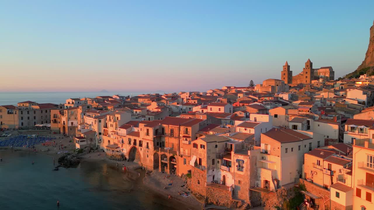 Ripresa cinematografica con drone sopra la costa di Cefalù, con la sua iconica cattedrale e i tetti dalle tonalità calde