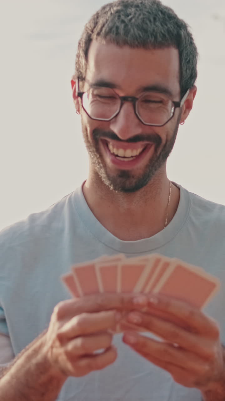 Friends Playing Cards at a Sunny Picnic, focus on the young man