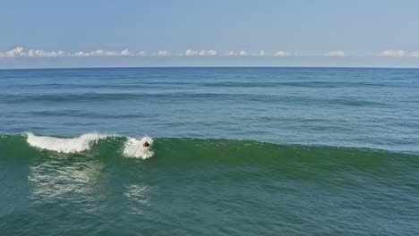 experienced surfer catching and riding beautiful wave, aerial view