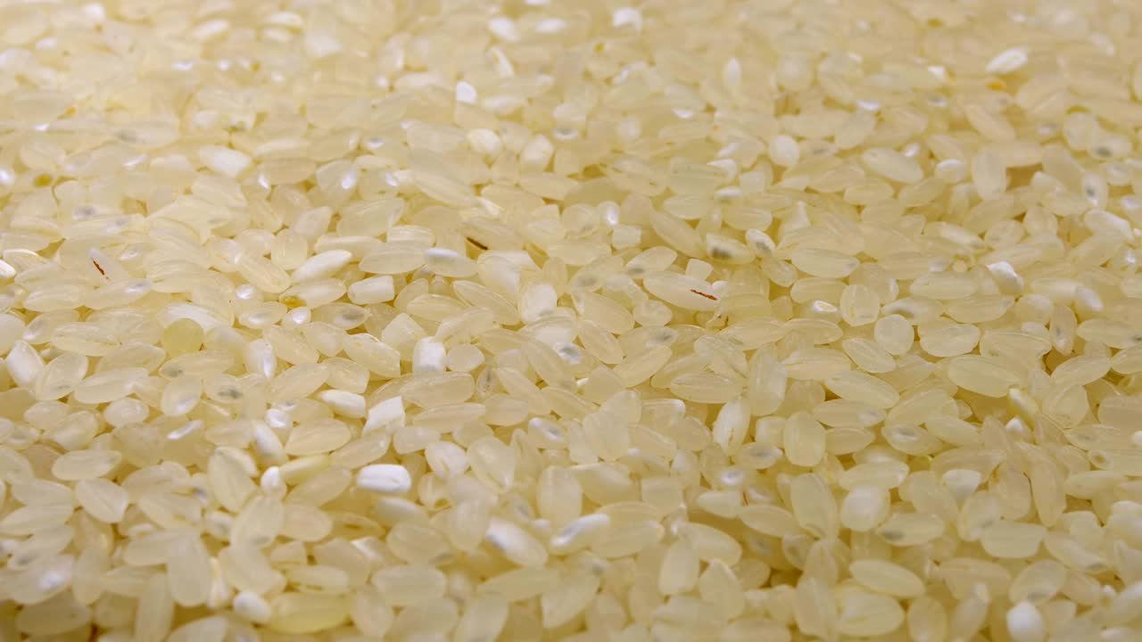 Chicchi di riso crudo ruotano in primo piano