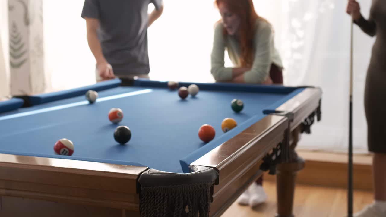 Crop man hitting white cue ball missing the shot in game room