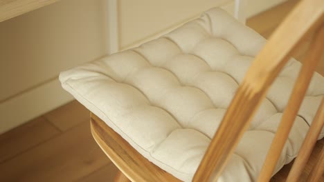 wooden chair with beige cushion