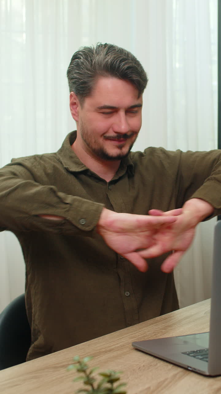 Middleaged man pleased clasping hands reviewing laptop report celebrates big deal closure at table