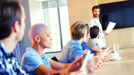 man giving presentation to his colleagues in conference room