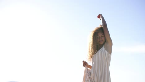 young woman with curly hair backlit by bright sun