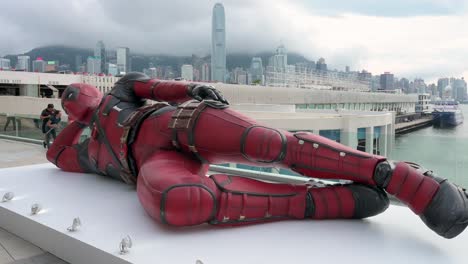 in front of hong kong’s skyline, locals and tourists visit the 8-meter deadpool figure, part of disney's promotion for the "deadpool and wolverine" film.