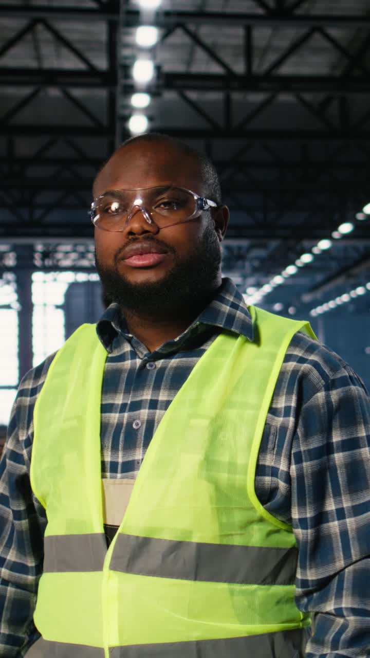 Vertical Video Engineer in safety hi vis vest uses tools in a fabrication workshop