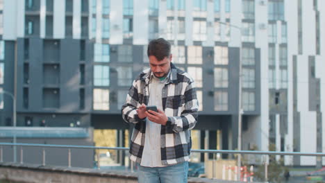 mature male tourist trying to catch a communication signal or internet on phone in downtown street