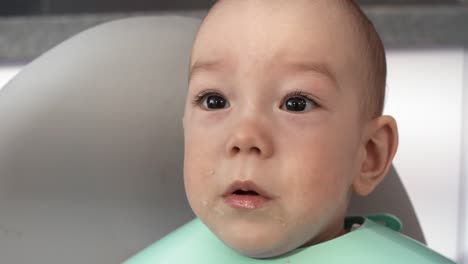 close up of stroppy baby boy crying during feeding