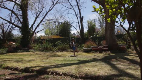 niño columpiándose en el jardín en un gran árbol columpio
