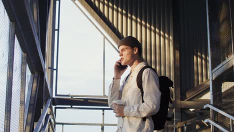 joven en las escaleras con café y teléfono