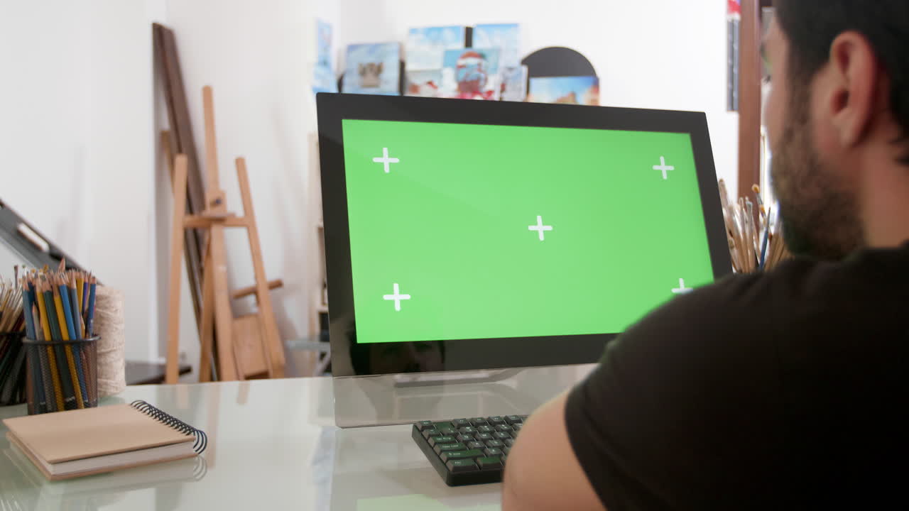 hombre trabajando en la computadora con pantalla verde