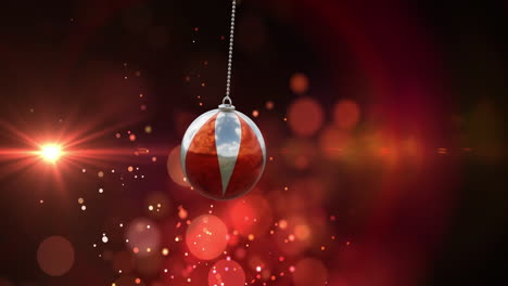 animation of christmas bauble and snow falling on red background