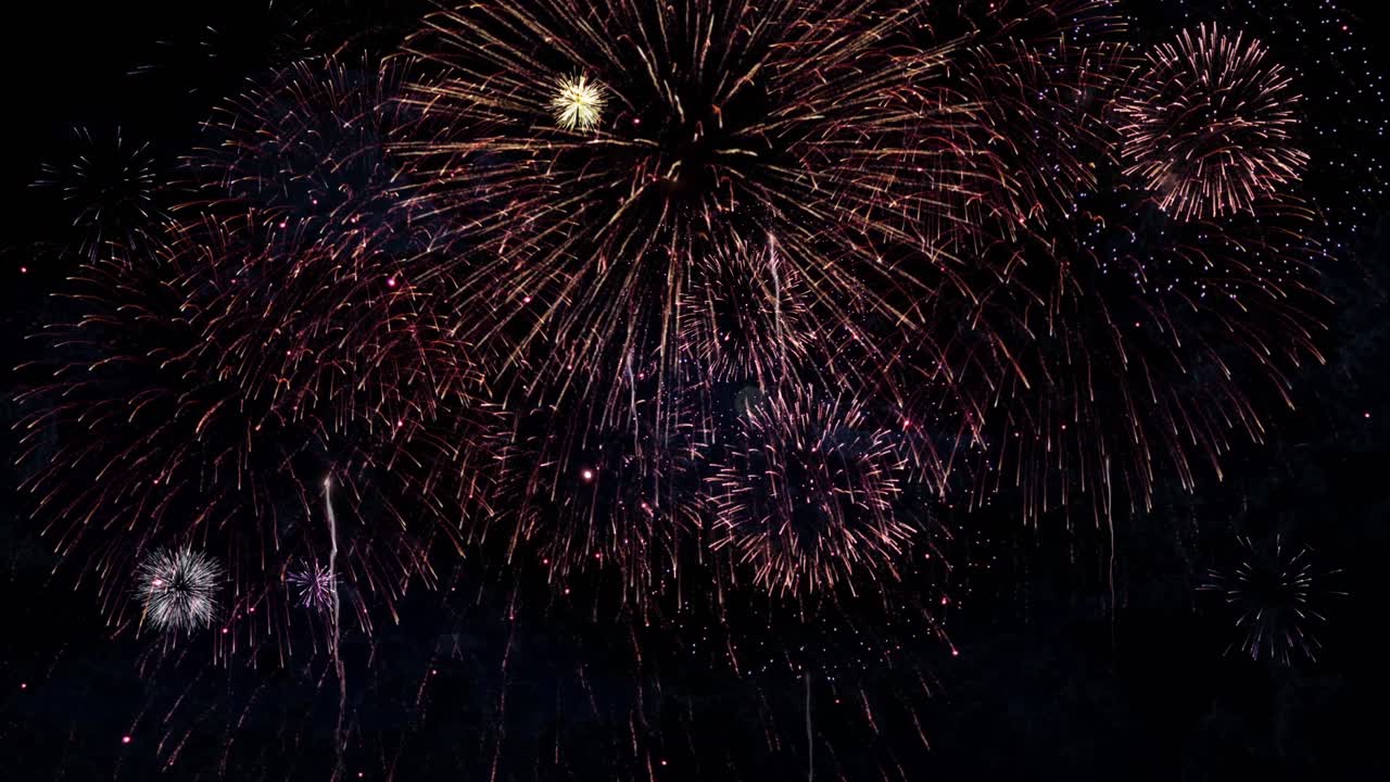Vídeo en 4K abstracto multicolor dorado brillante con luces bokeh de fuegos artificiales en el cielo nocturno para la víspera de Año Nuevo