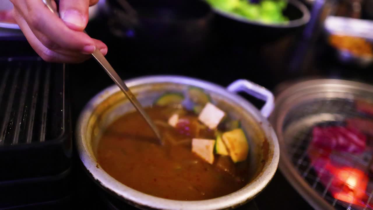 echar sopa en un cuenco con pedazos de tofu