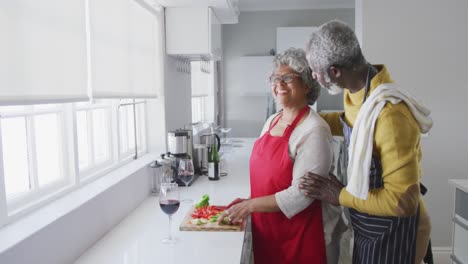 una pareja mayor afroamericana cocinando en casa. distanciamiento social en cuarentena