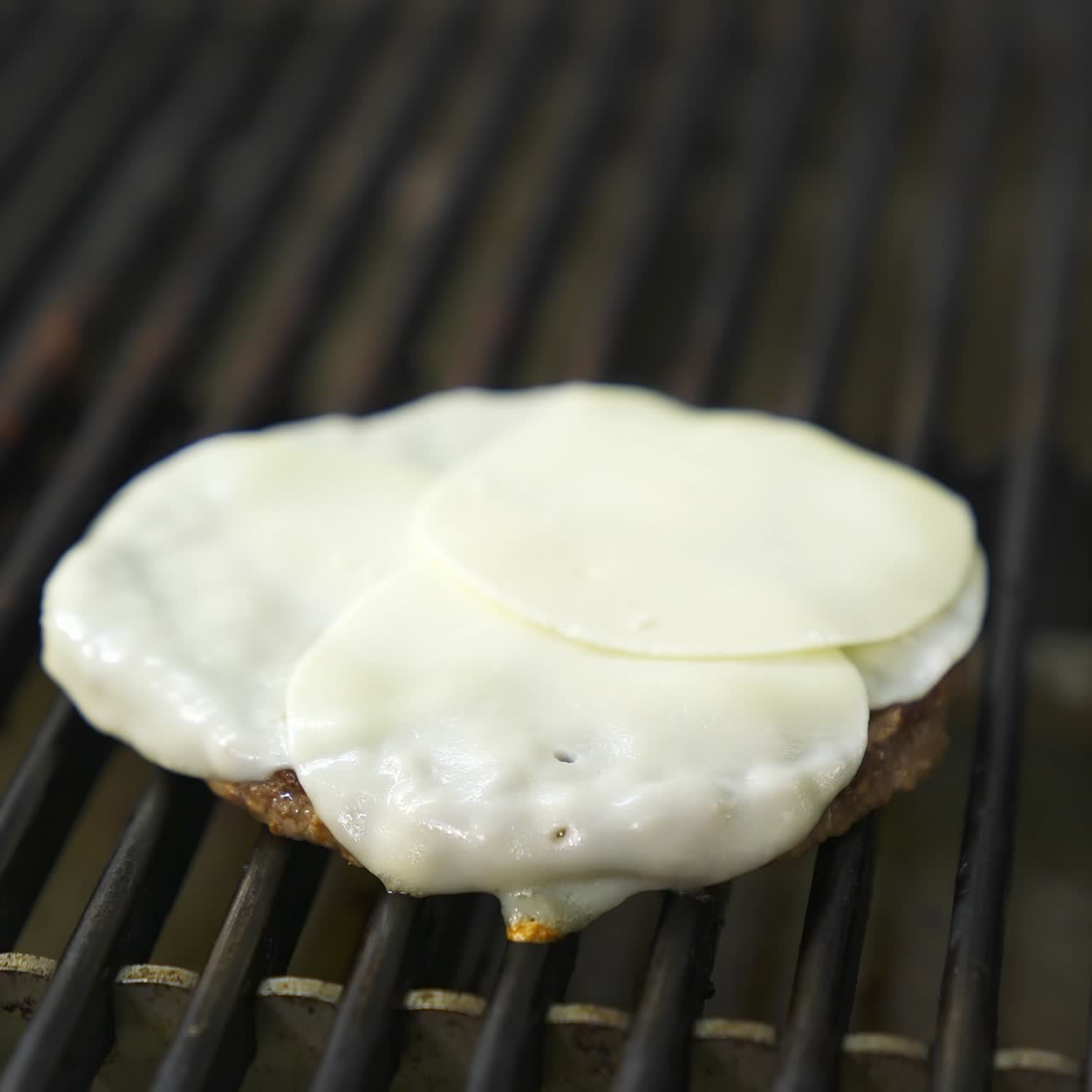 Cutlet for burger with egg on top are fried on a large grill. Fast food concept. Tasty video