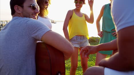hombres y mujeres multiétnicos disfrutando de una fiesta en la playa.