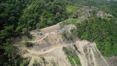 Aerial shot of construction site with containers nestled in the lush green mountains of La Guaira, Venezuela