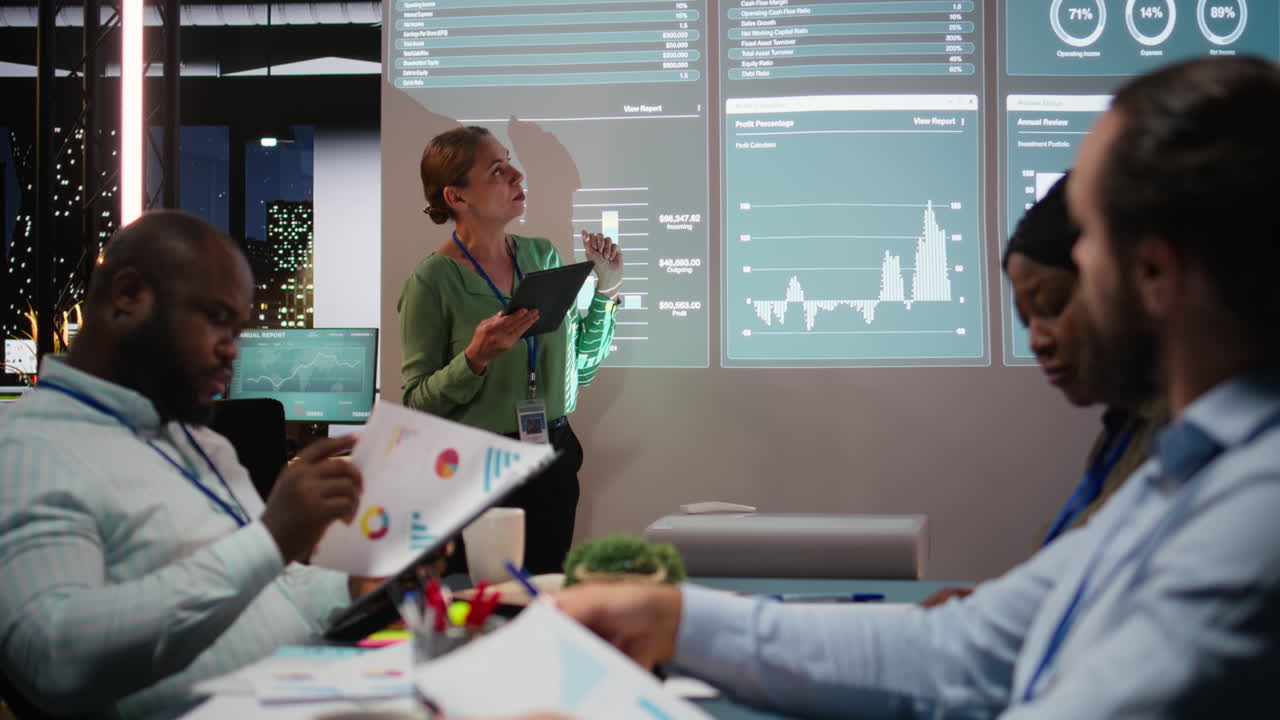 Business partners reviewing monthly data reports in night time meeting