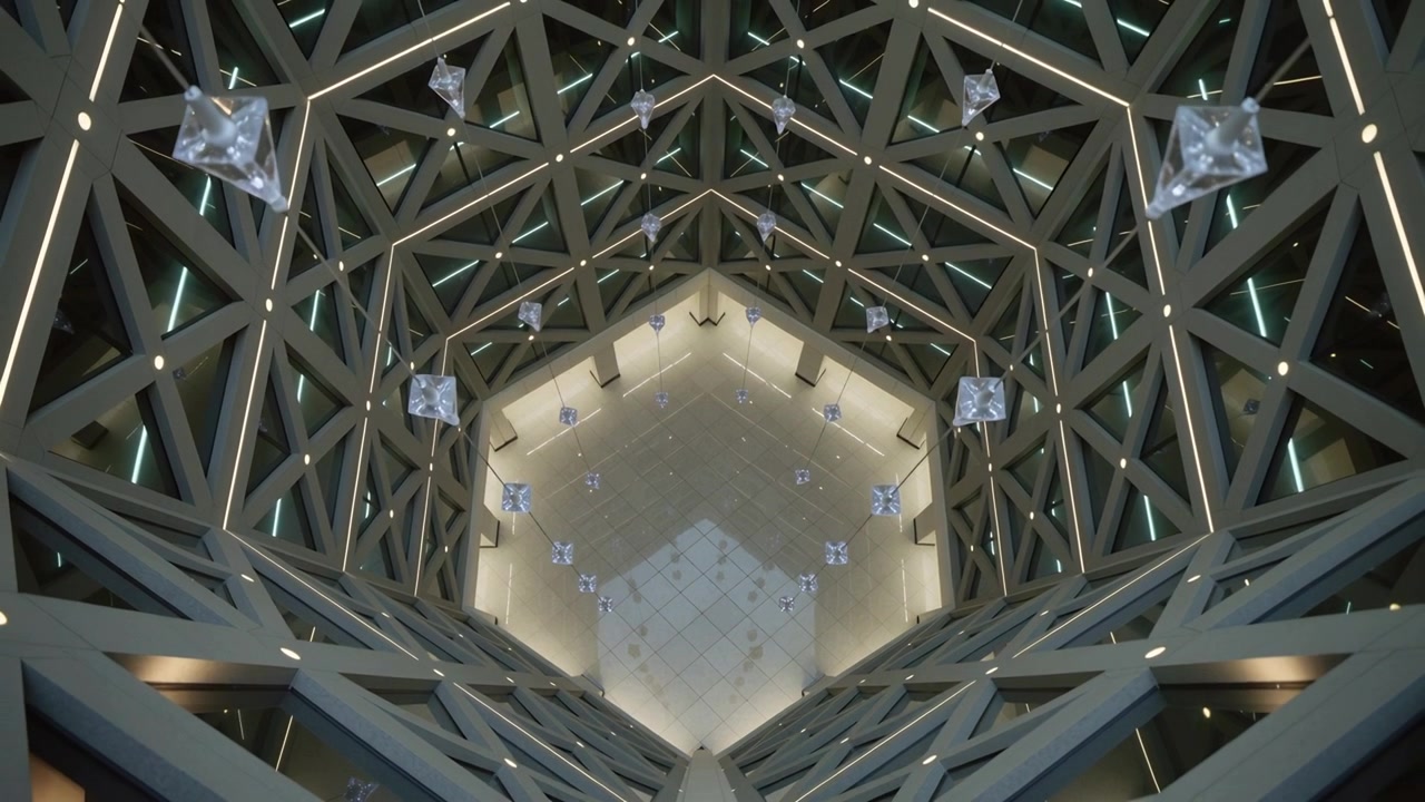 Movimento di camera che zooma verso l'atrio esagonale centrale nella hall, rivelando luci a reticolo triangolare