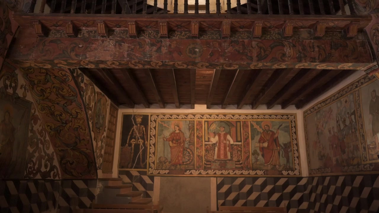 Vista verso l'alto di una galleria in legno ornata all'interno di una storica cappella spagnola