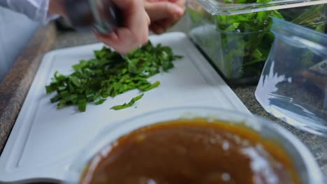 un chef prepara una receta utilizando solo productos orgánicos frescos cosechados con métodos agrícolas renovables y sostenibles en la selva amazónica: cortar plantas de hojas verdes