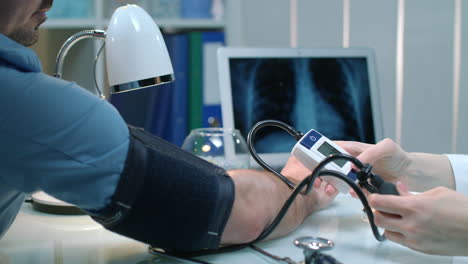 médico femenino comprueba la presión arterial