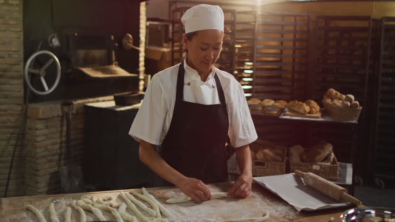 Animasjon av en glad asiatisk kvinnelig baker som tilbereder rundstykker på et bakeri.