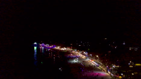 Wide-Aerial-of-Beach-with-Lights-and-Fireworks-at-the-Full-Moon-Party,-Koh-Phangan,-Thailand