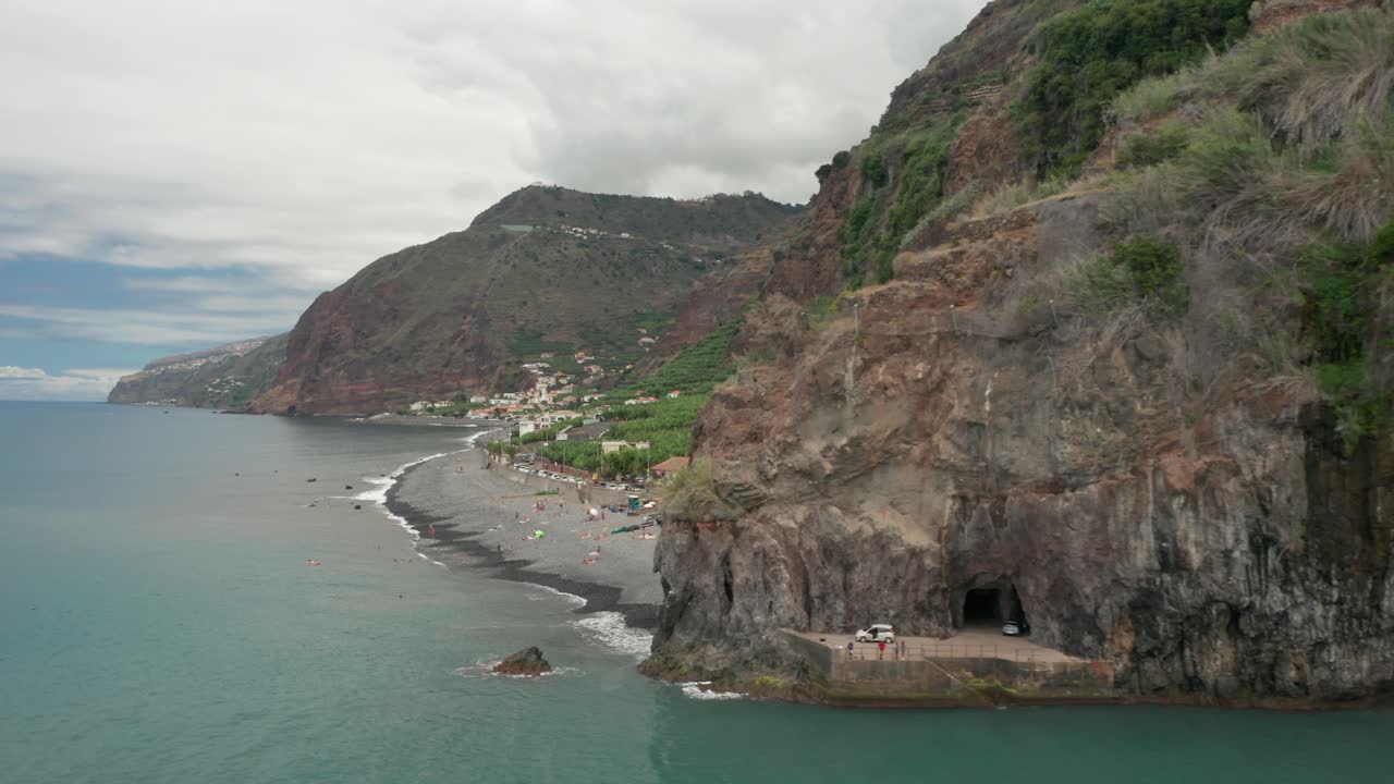 Natural cliffs of Madeira Island with grey beaches on shores, aerial