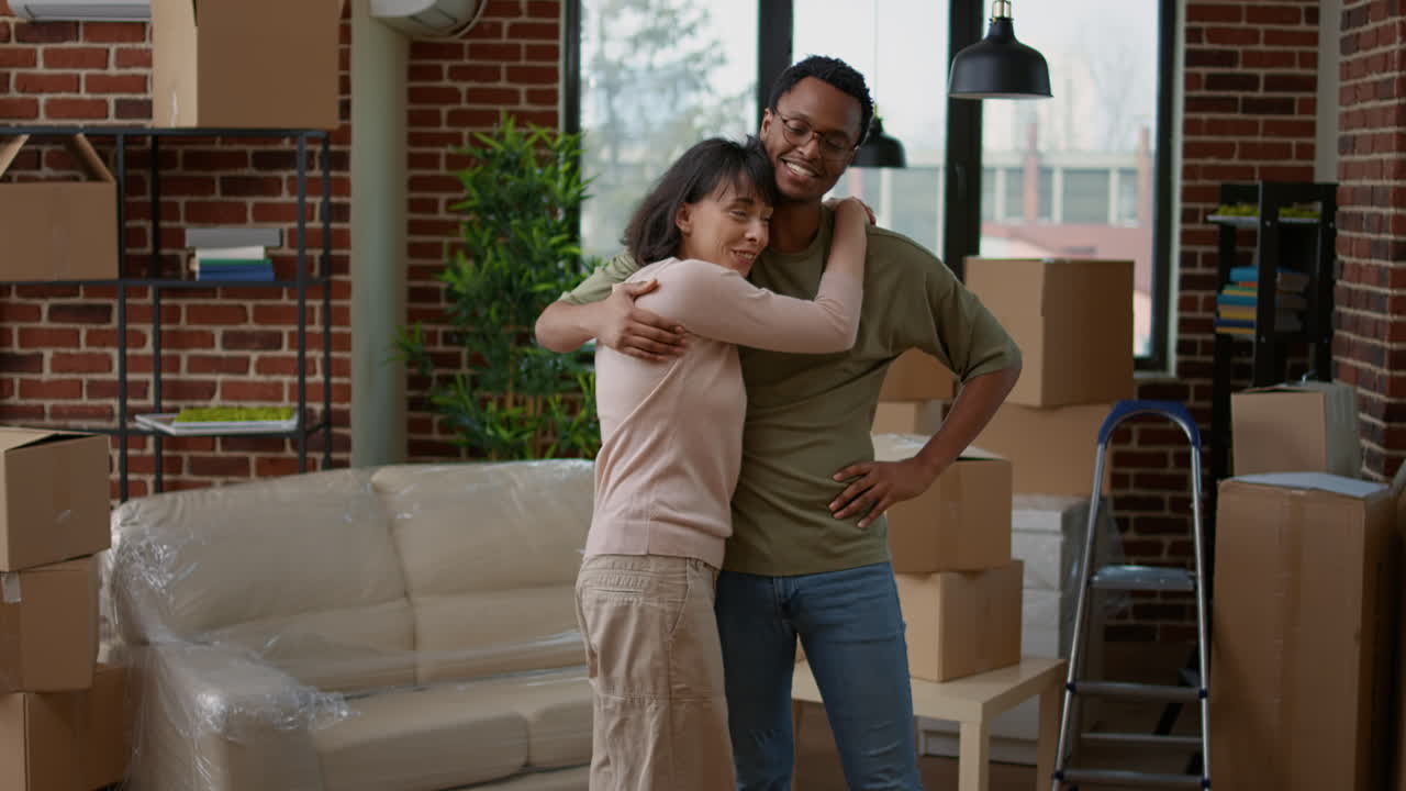Wife and african american husband embracing in new rented home
