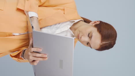 video vertical de una mujer de negocios cansada quedándose dormida en la computadora portátil.