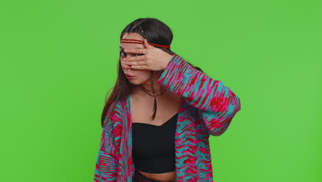 nosy curious young woman girl closing eyes with hand and spying through fingers hiding peeping
