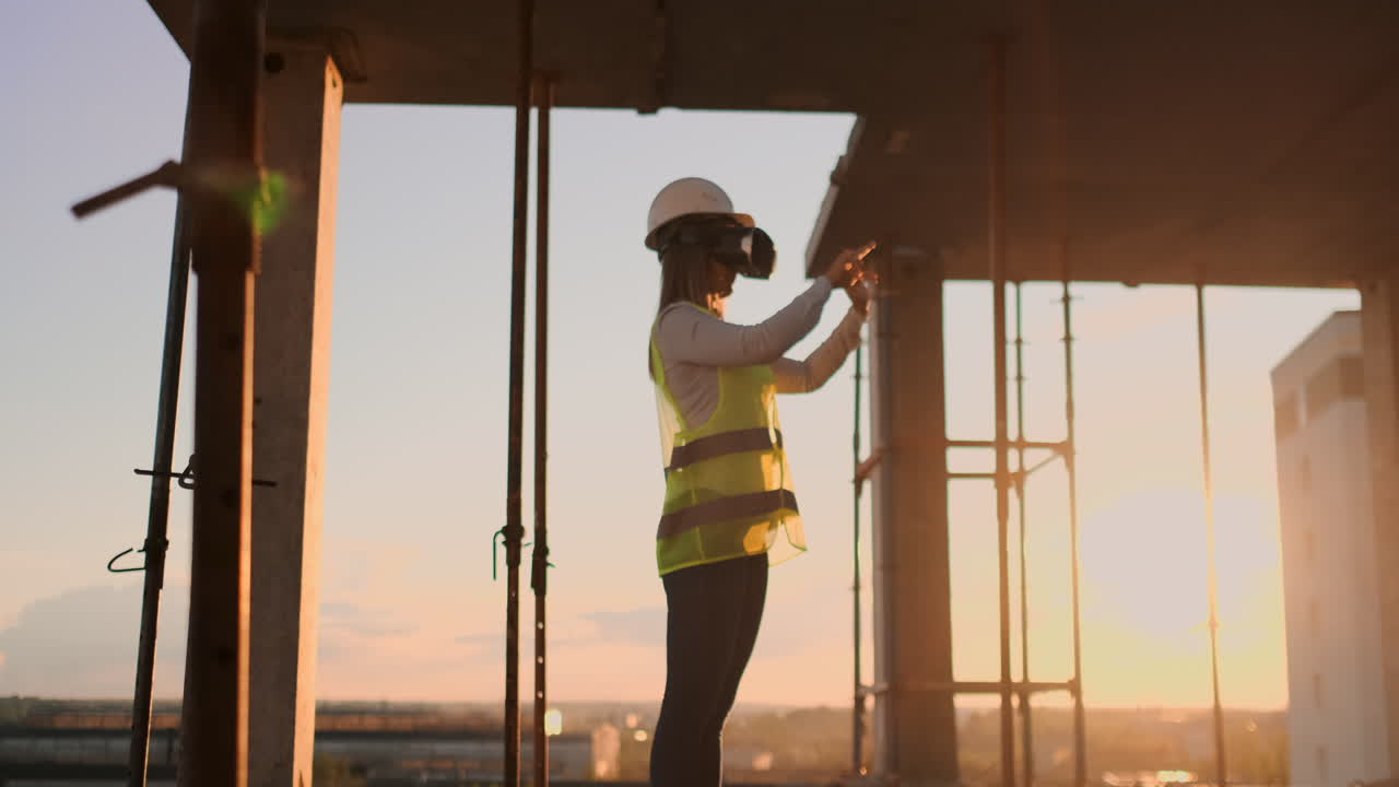 inspector mujer en gafas vr y casco comprueba el progreso de la construcción de un rascacielos moviendo sus manos al atardecer visualizando el plan del edificio