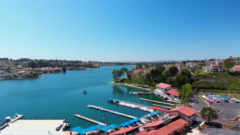 Aerial-fly-over-of-community-lake-mission-viejo-with-a-boat-and-paddleboard