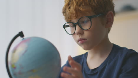 boy looking at a globe