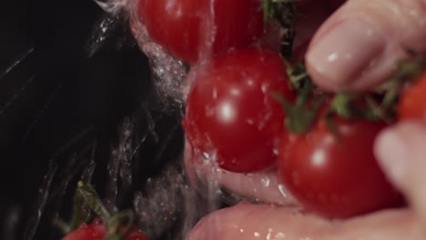 los tomates maduros se enjuagan cuidadosamente bajo el grifo de agua para la ensalada - cerrar