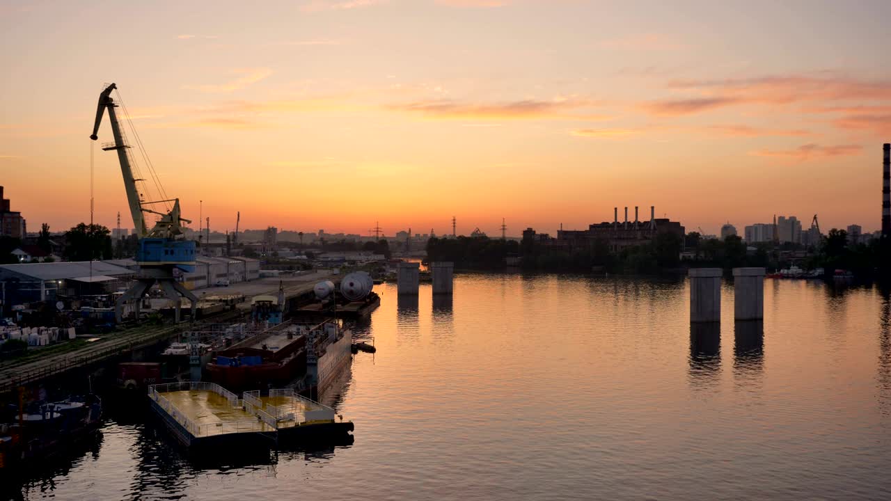 공기 대기와 강 물, 생태, 일몰과 함께 강 근처의 산업 공장 위의 공중 풍경