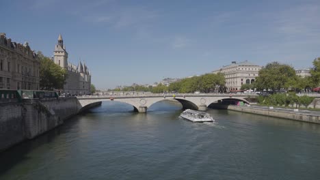 Tourist-Boat-Going-Under-Pont-Saint-Michel-Bridge-Crossing-River-Seine-In-Paris-France-With-Tourists-And-Traffic