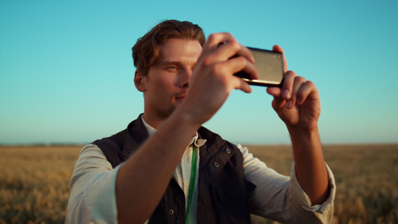 수확장에서 스마트폰을 들고 있는 농부. 농업 노동자 초상화에 초점을 맞 ⁇ 습니다.