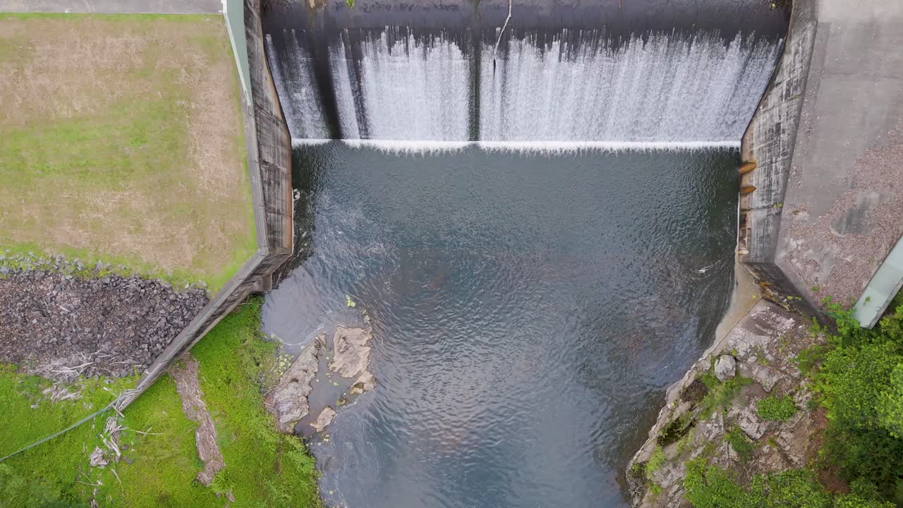Aerial view of water cascading over dam