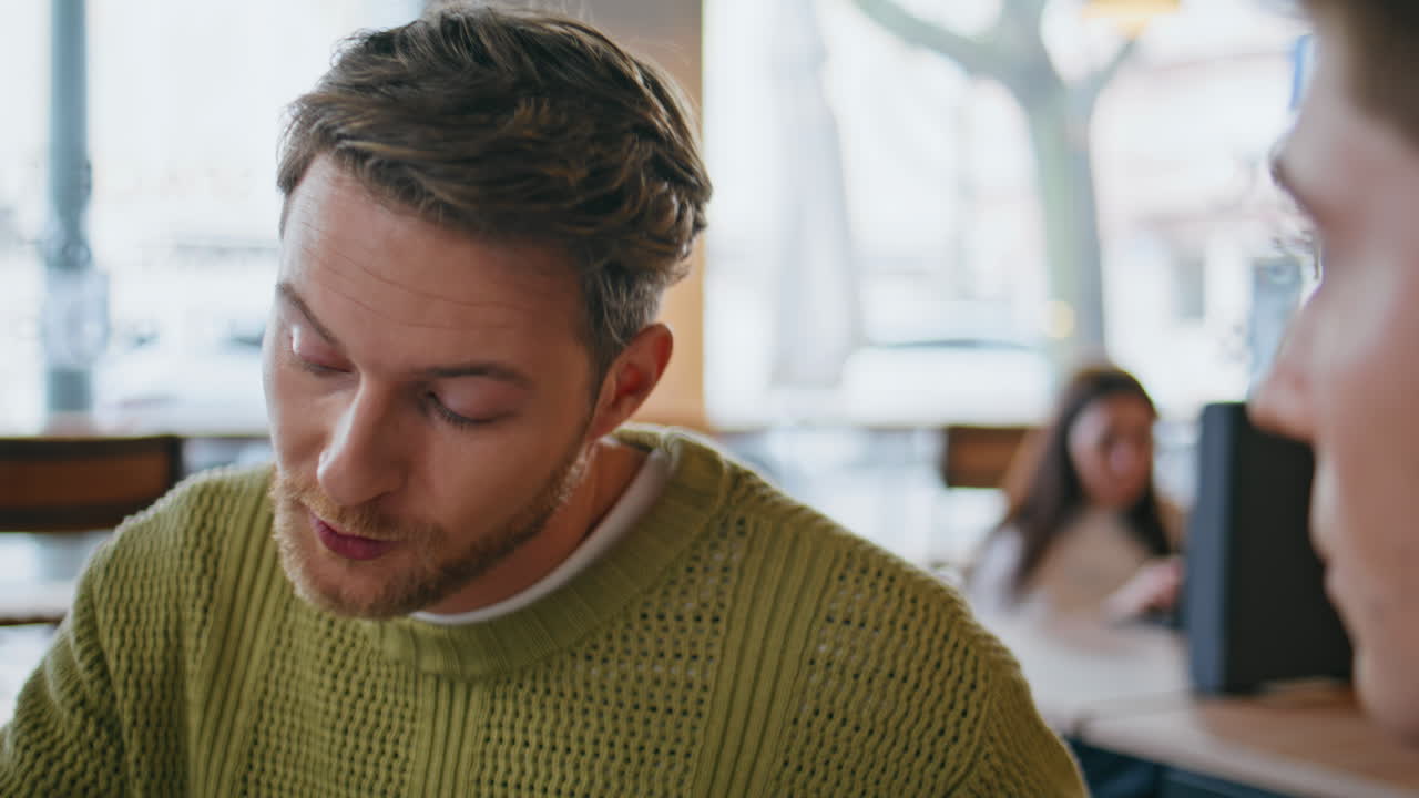 Primo piano di due uomini d'affari che parlano in un moderno spazio di coworking. Due uomini discutono