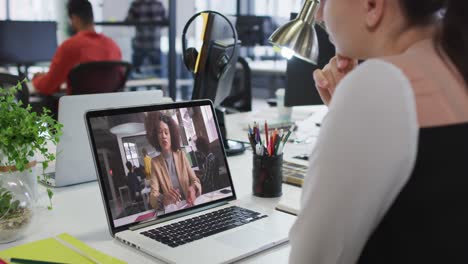 Caucasian-businesswoman-sitting-at-desk-using-laptop-having-video-call-with-female-colleague