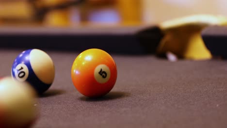 hitting balls into pockets on billiard table - close