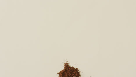 Video-of-pile-of-roasted-brown-coffee-beans-over-white-background