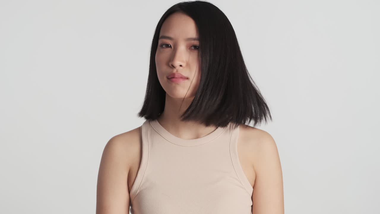 카메라를 향해 머리를 흔들고 있는 아시아 여성.