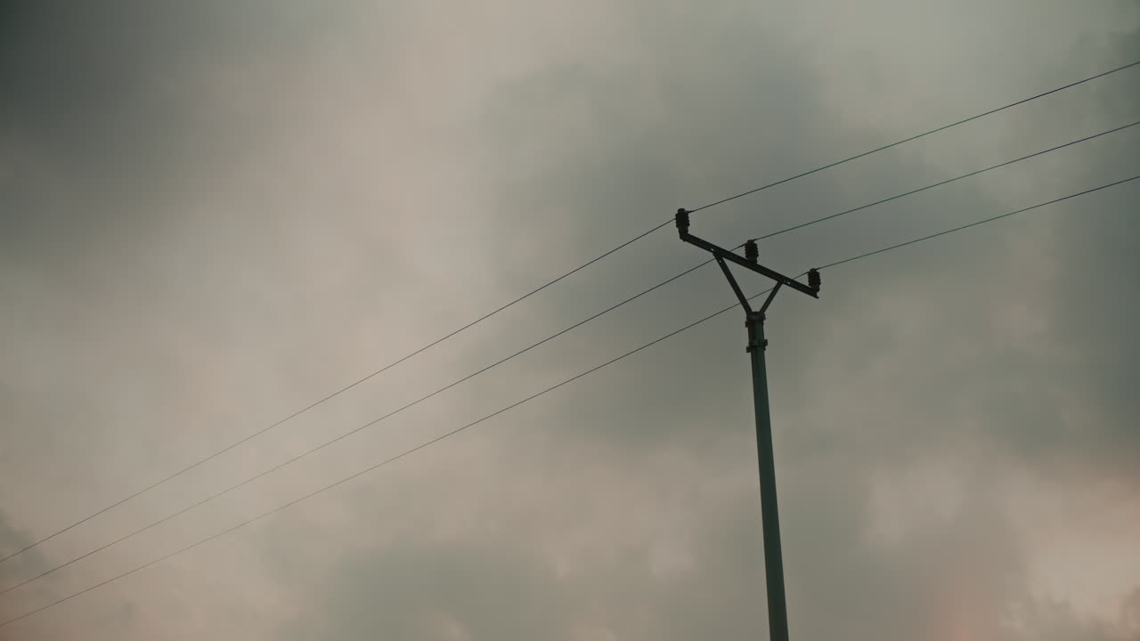 전신 기둥 과 케이블 들 이 구름 을 고 있는 하늘
