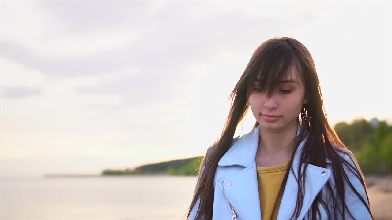 해가 지는 해변에 있는 젊은 여성