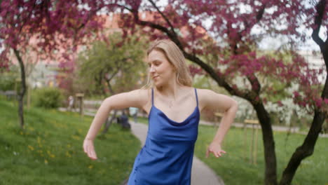 blonde woman dancing alone in a park